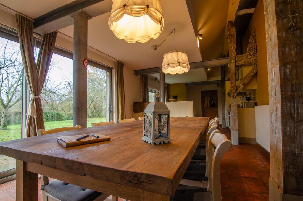 a dining room with a wooden table and chairs at Vakantiewoning De Luysmolen in Bocholt