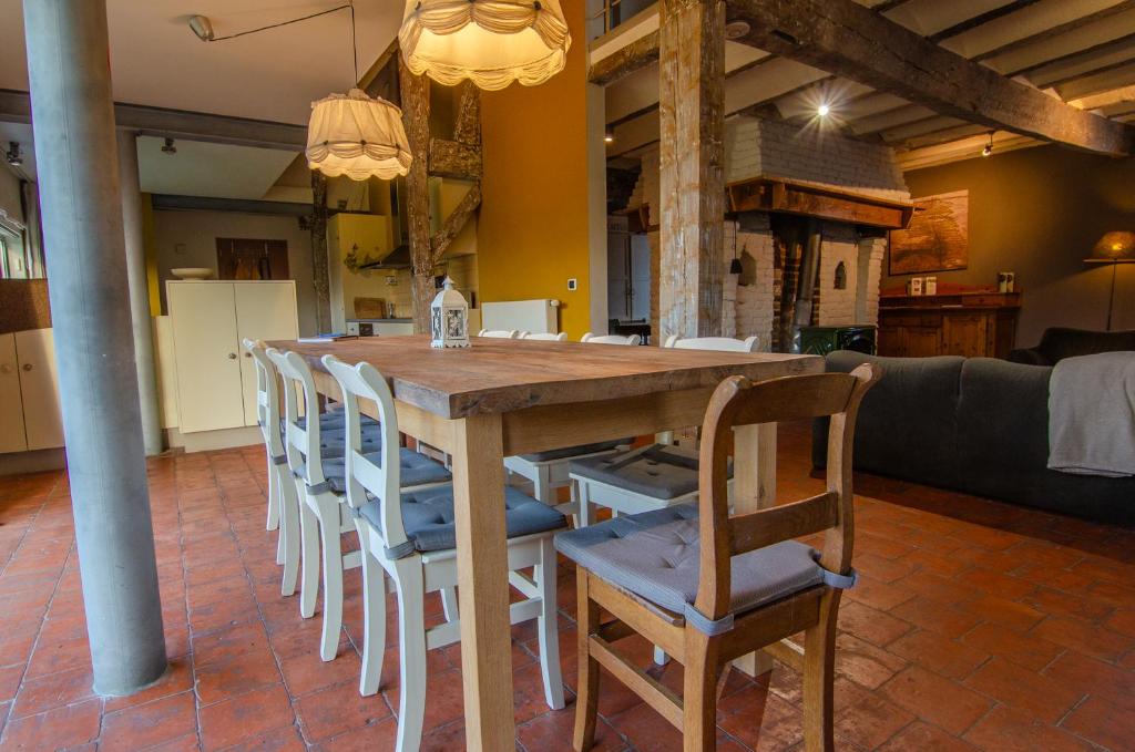 a wooden table and chairs in a room at Vakantiewoning De Luysmolen in Bocholt