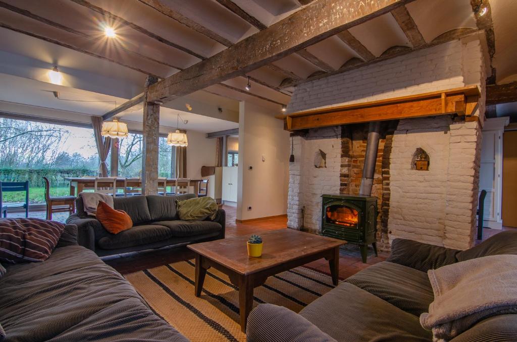 a living room with couches and a fireplace at Vakantiewoning De Luysmolen in Bocholt