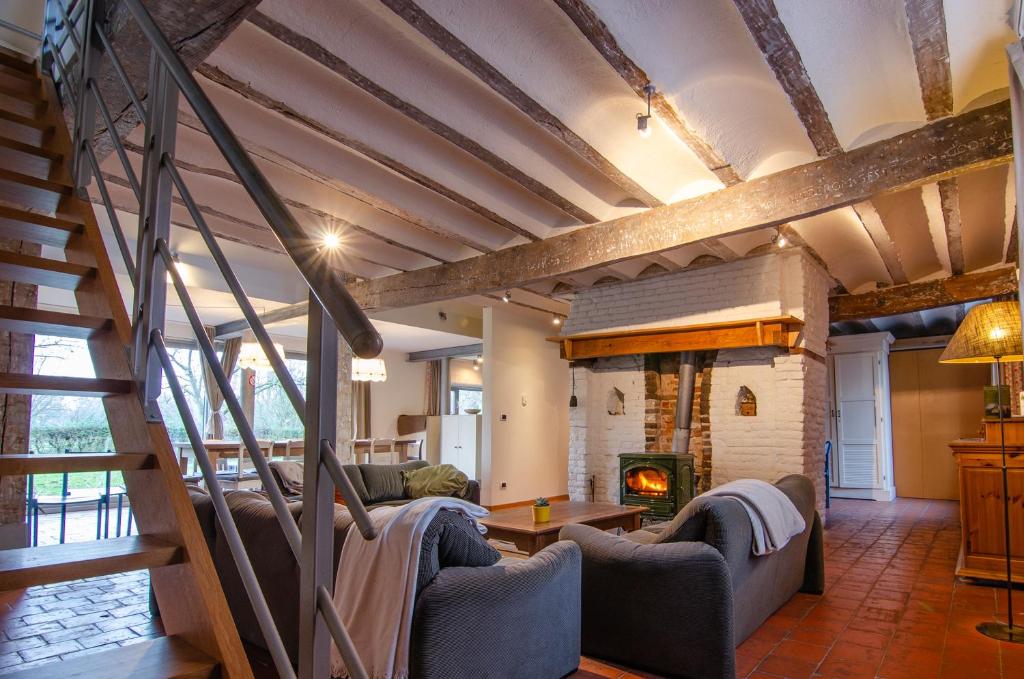 a living room with couches and a fire place at Vakantiewoning De Luysmolen in Bocholt