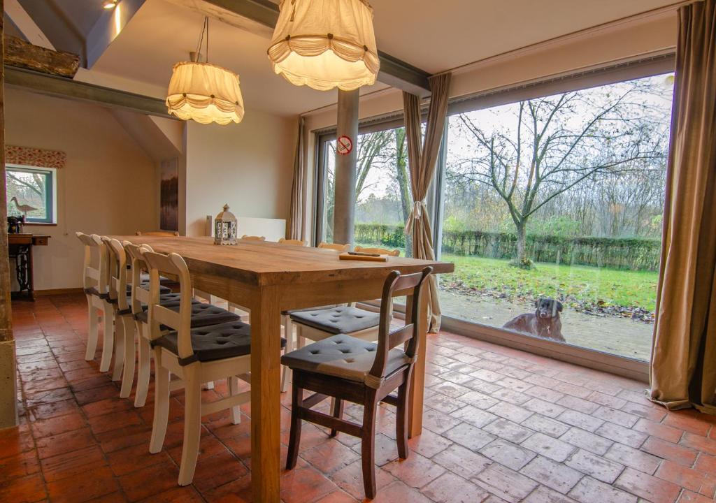 a dining room with a wooden table and chairs at Vakantiewoning De Luysmolen in Bocholt