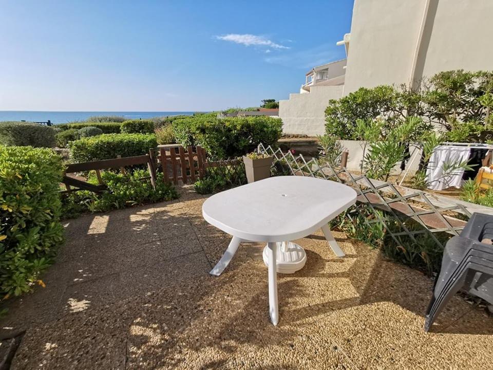 une table blanche assise au sol avec l'océan en arrière-plan dans l'établissement 138 Thalacap C2, au Cap d'Agde