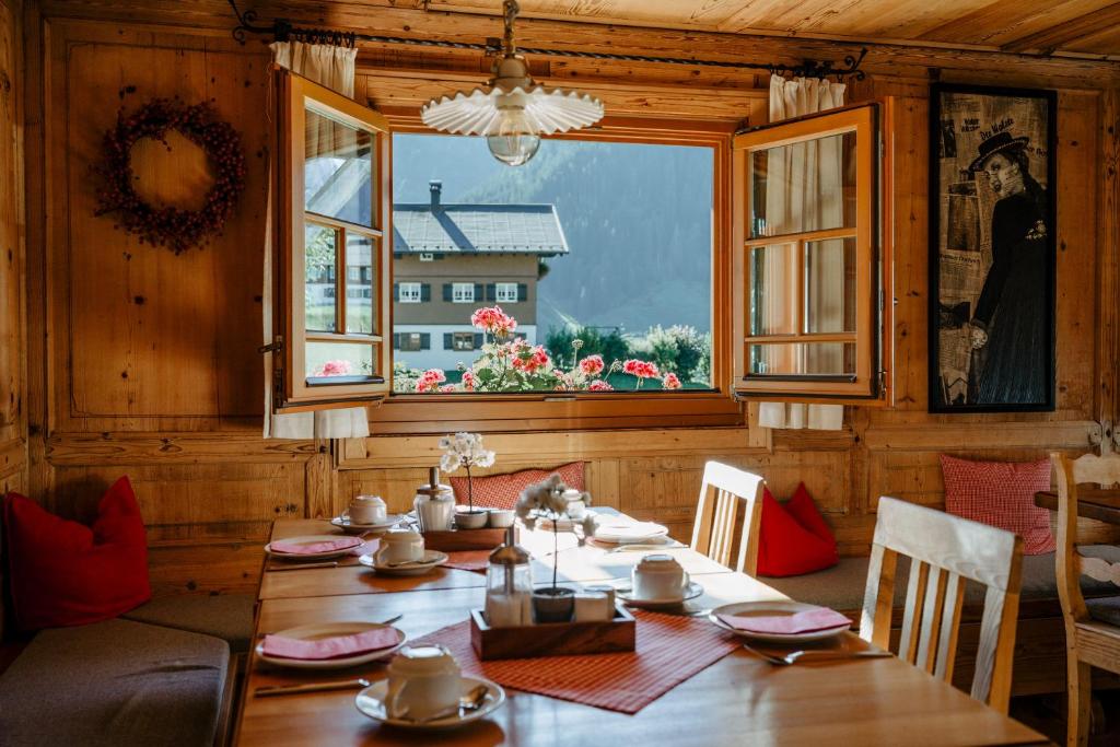 ein Esszimmer mit einem Tisch und einem Fenster in der Unterkunft Gästehaus Fritz in Mittelberg