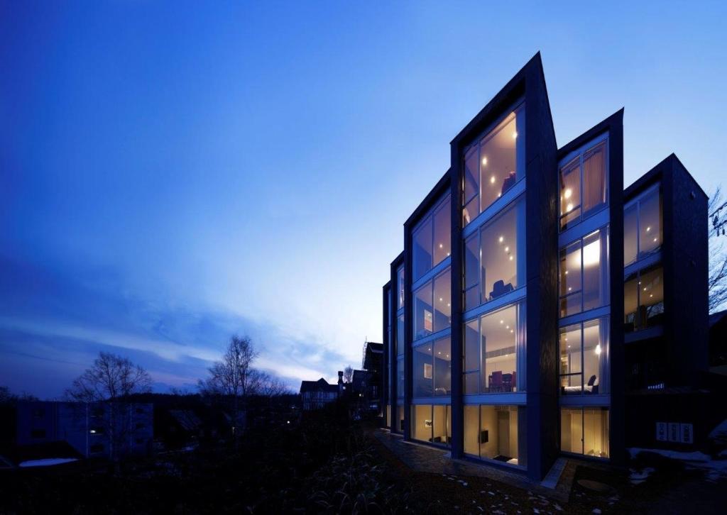 a building with glass windows at dusk at Terrazze in Niseko