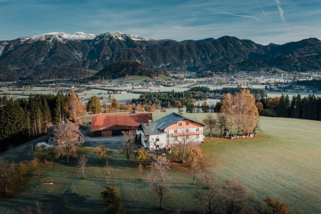 an aerial view of a house in a field with mountains at Bergblickapartments in Spital am Pyhrn