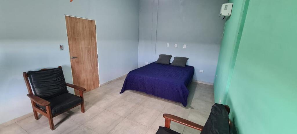 ein Schlafzimmer mit einem lila Bett und einem Stuhl in der Unterkunft Quinta Loma Hermosa in Diamante