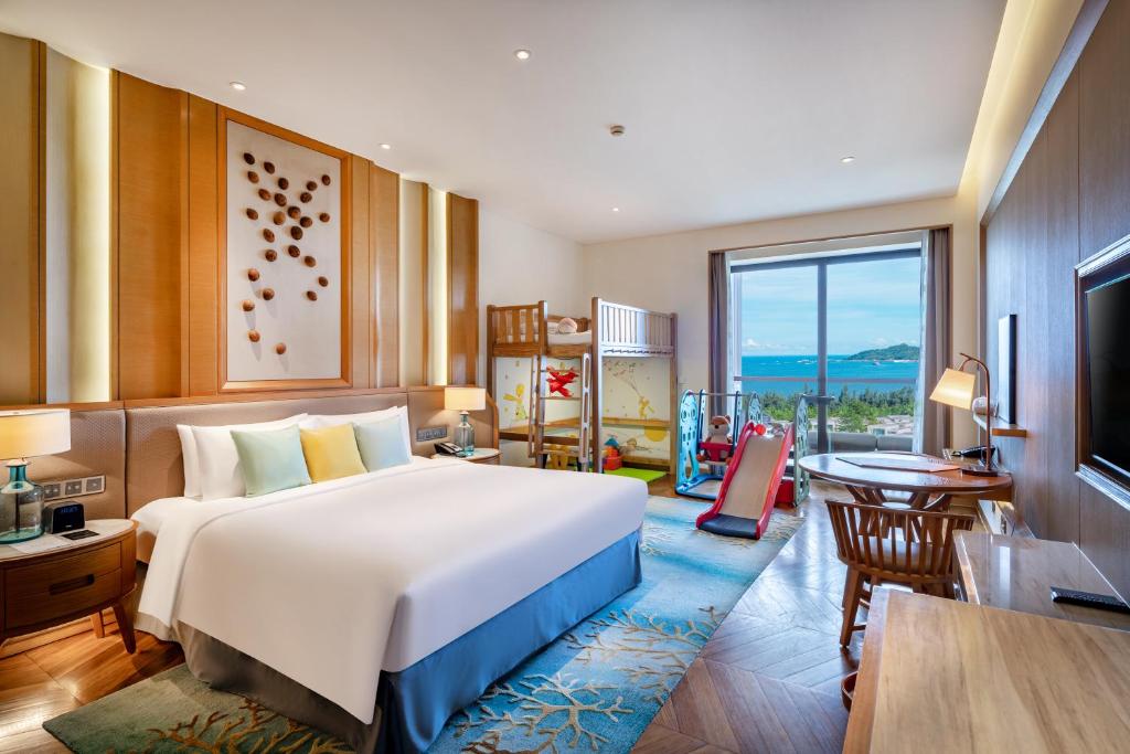 a bedroom with a large bed and a large window at Sofitel Sanya Leeman Resort in Sanya