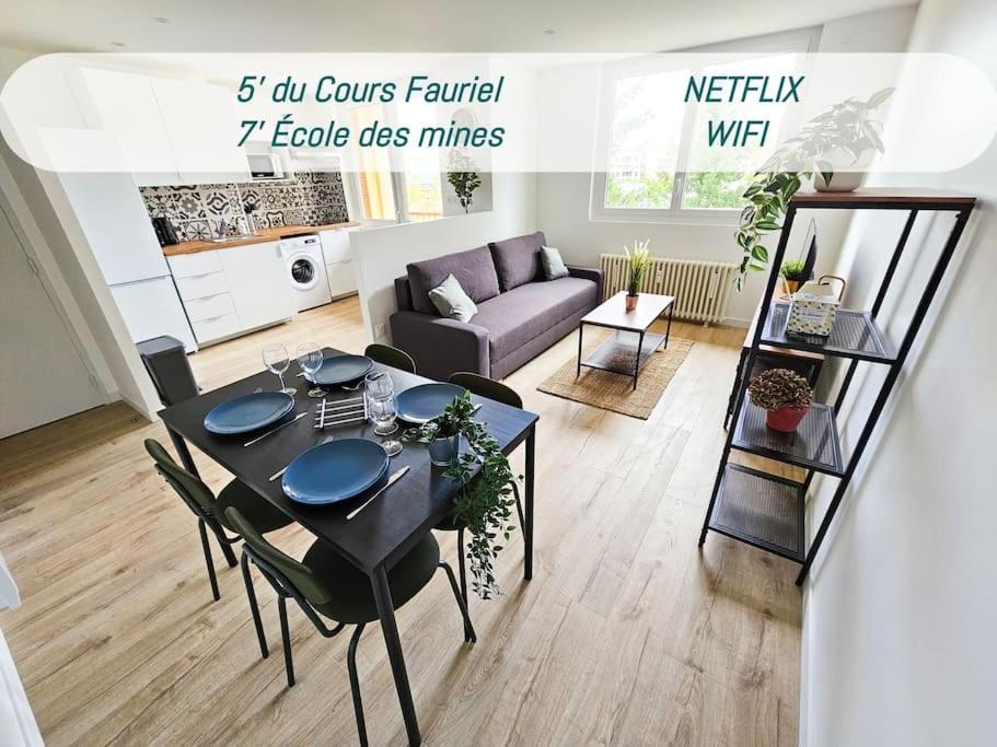 a living room with a table and a couch at Le nid élégance du 4ème étage in Saint-Étienne