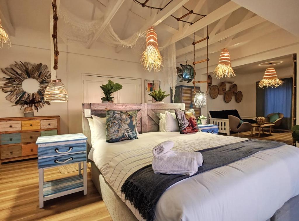 a bedroom with a large bed and a living room at Sun&Sand Camps Bay in Cape Town