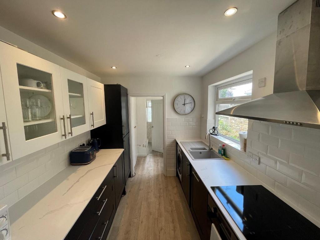 a kitchen with a sink and a clock on the wall at Windsor Stunning Three Bedroom House in Windsor