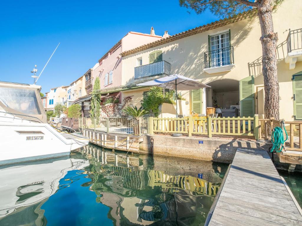 un bateau dans un canal devant une maison dans l'établissement Holiday Home Bleu Azur by Interhome, à Grimaud