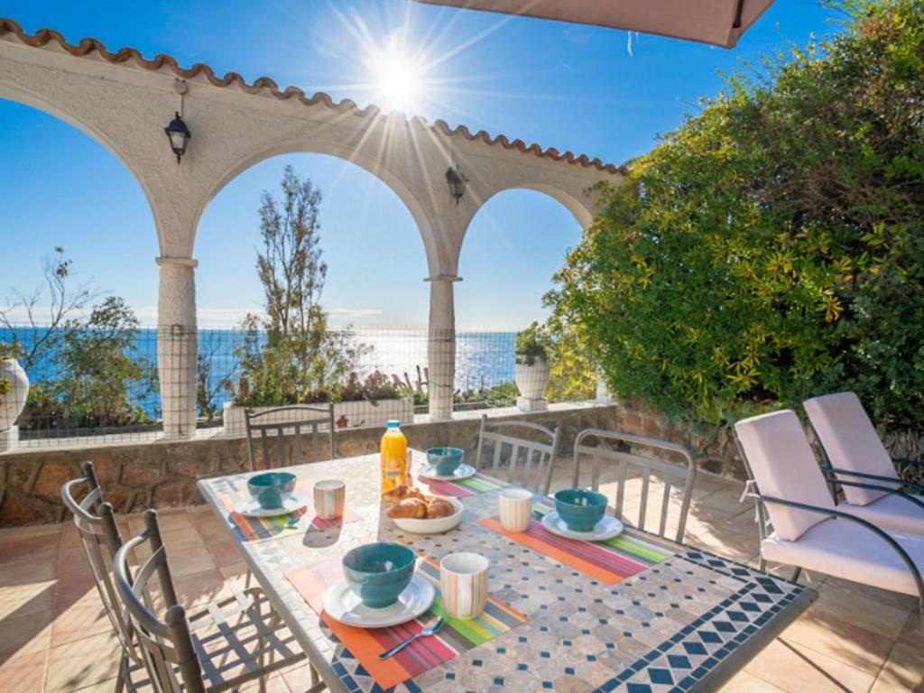 einen Tisch und Stühle auf einer Terrasse mit Meerblick in der Unterkunft Holiday Home La Rocade - TEU110 by Interhome in Espéro-Pax