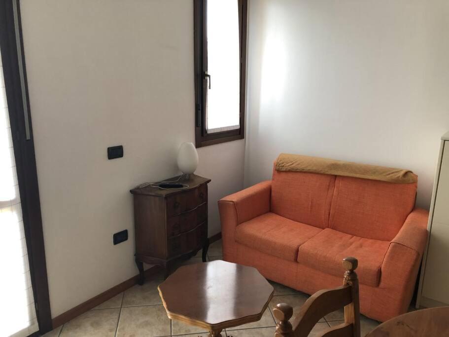 ein Wohnzimmer mit einem Sofa und einem Tisch in der Unterkunft Appartamento comodo per brevi periodi in Forlì