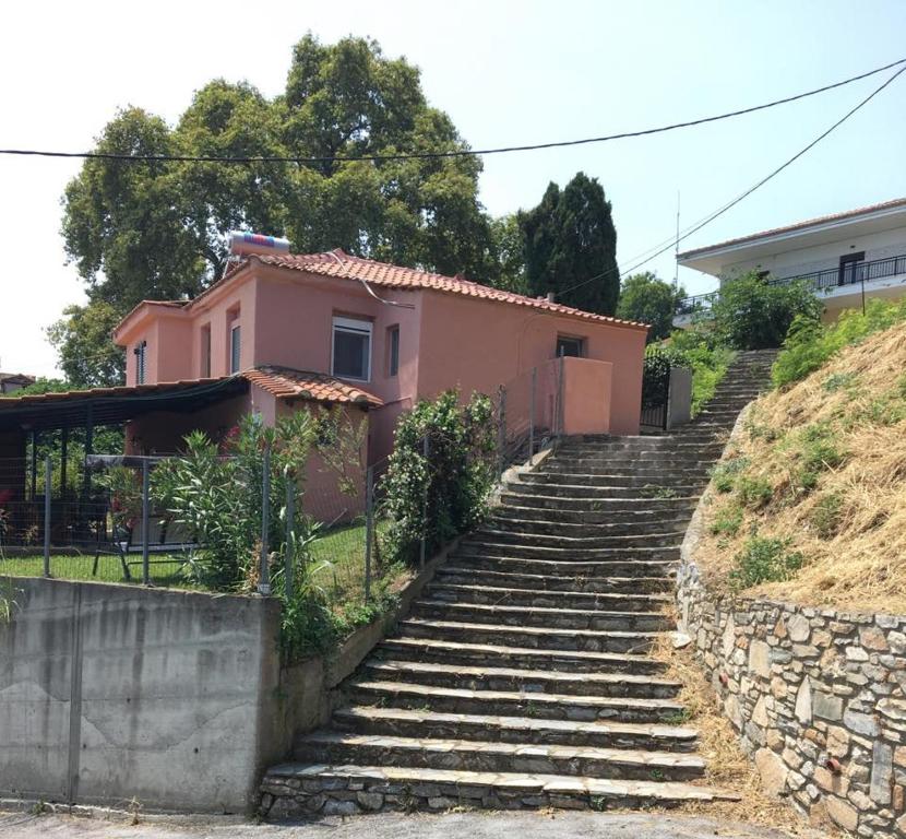 un conjunto de escaleras que conducen a una casa rosa en Stamoula' s house, en Aigáni