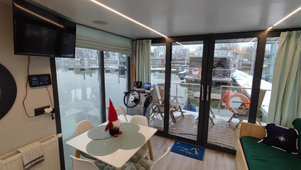 Zimmer mit einem Tisch und Stühlen sowie einem Balkon in der Unterkunft Houseboat Water Boy apartament pływający dom na wodzie łódź in Breslau