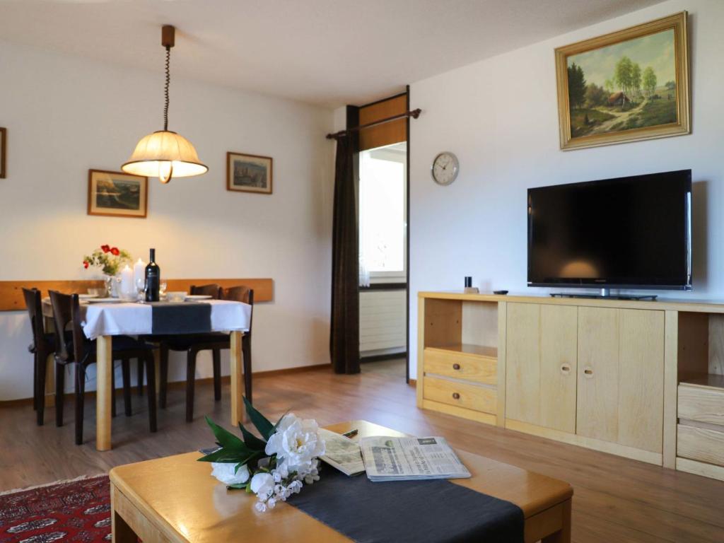 a living room with a television and a dining room at Apartment Allod Park Haus C 605 by Interhome in Davos