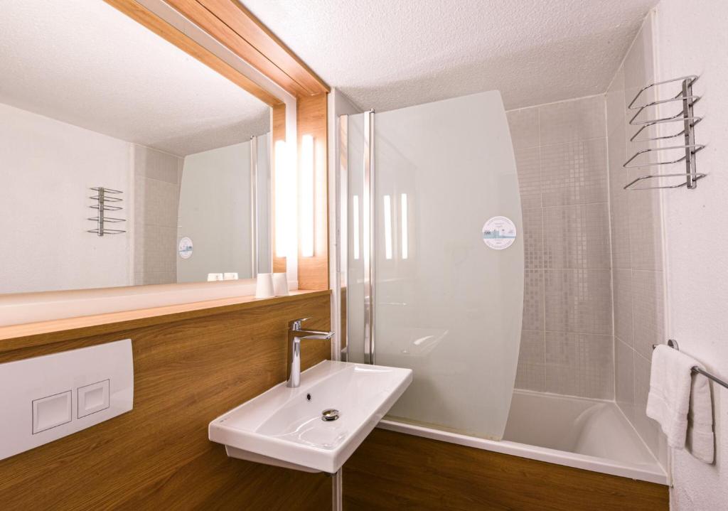 a bathroom with a sink and a shower at Kyriad Villeneuve Saint Georges - Hôtel rénové in Villeneuve-Saint-Georges