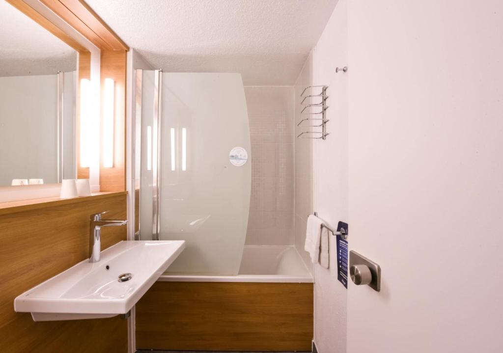 a white bathroom with a sink and a shower at Kyriad Villeneuve Saint Georges - Hôtel rénové in Villeneuve-Saint-Georges