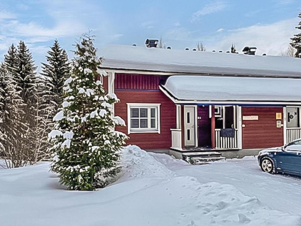 ein rotes Haus mit einem Auto im Schnee in der Unterkunft Holiday Home Tintintupa by Interhome in Tahkovuori