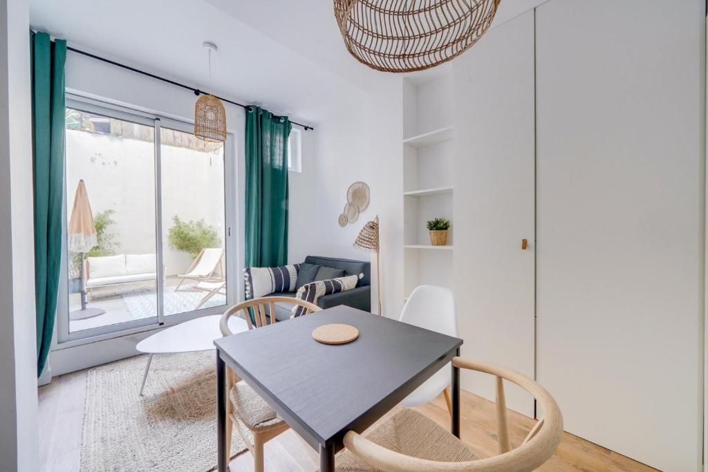 ein Esszimmer und ein Wohnzimmer mit einem Tisch und Stühlen in der Unterkunft Beautiful apartment in Chartrons with terrace in Bordeaux