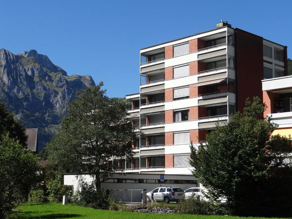 um edifício de apartamentos alto com montanhas ao fundo em Apartment Parkweg 9-602 by Interhome em Engelberg