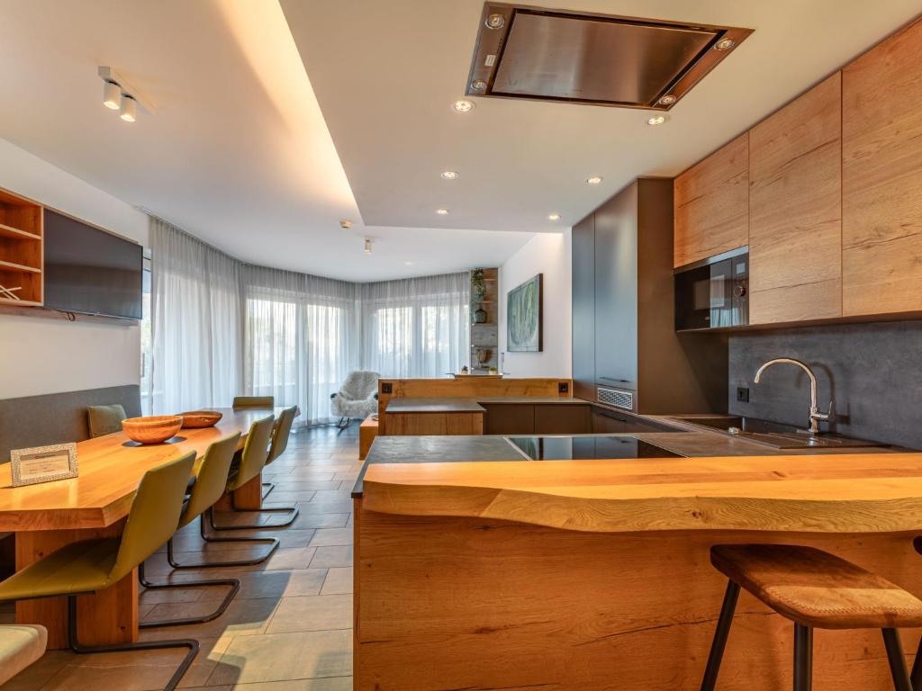 a kitchen with wooden counters and wooden tables and chairs at Apartment Verditz alpe maritima Ski & See - Top 1 by Interhome in Annenheim