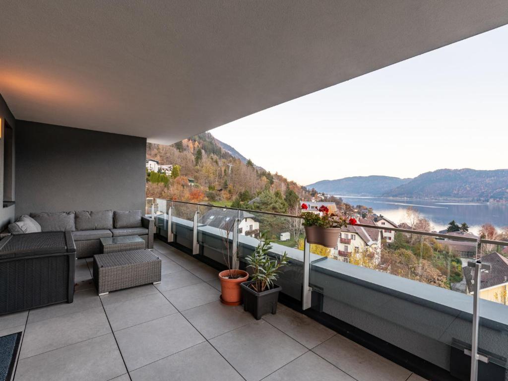 d'un balcon avec des canapés et une vue sur l'eau. dans l'établissement Apartment Adlerblick alpe maritima Ski & See - 22 by Interhome, à Annenheim