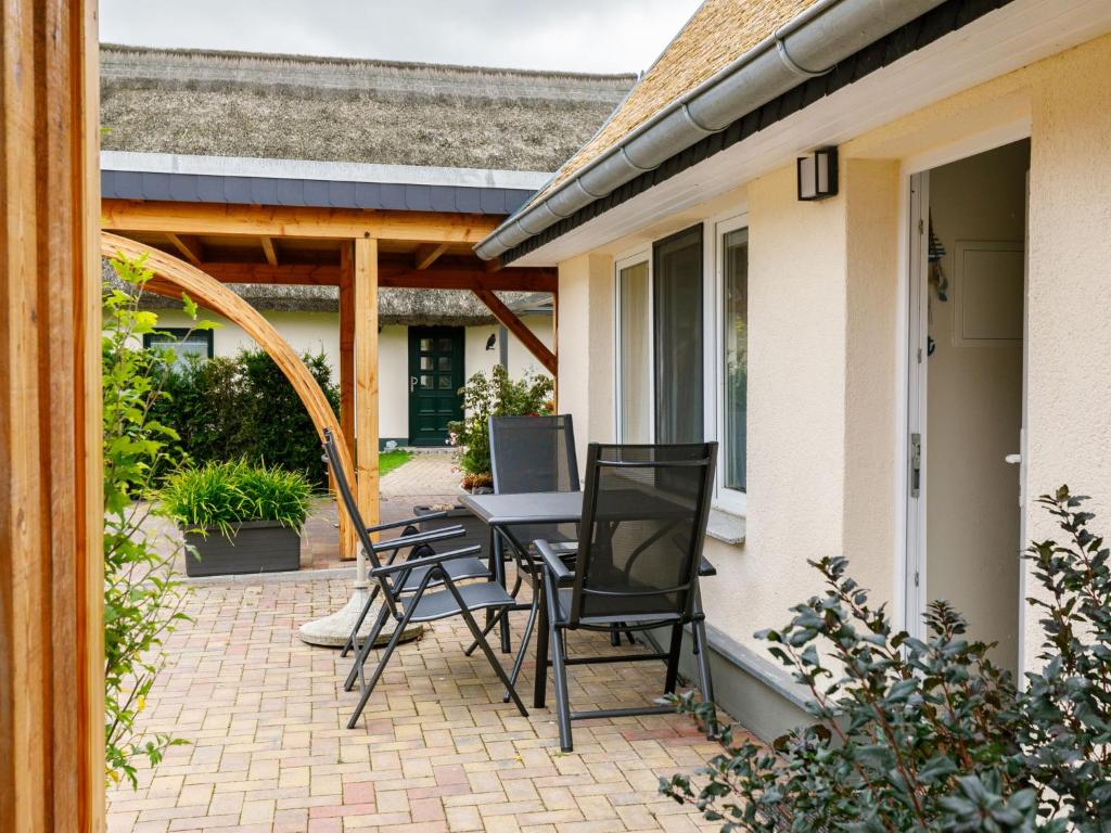 eine Terrasse mit Stühlen und einem Tisch mit einem Laptop in der Unterkunft Holiday Home Fischerbungalow by Interhome in Zempin