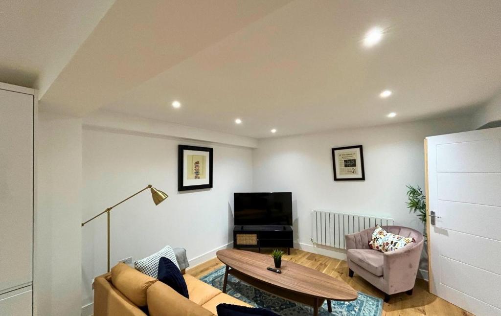 uma sala de estar com um sofá e uma mesa em London Mitcham Beautifully Presented Two Bedroom Apartment em Mitcham