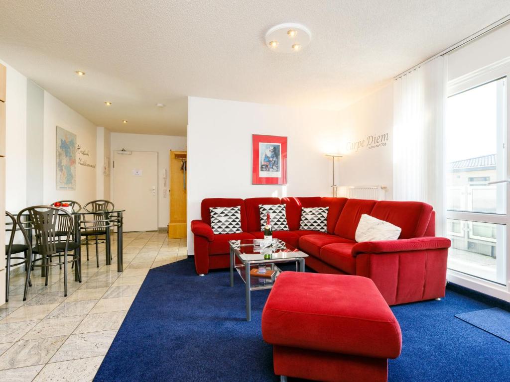 - un salon avec un canapé rouge et une table dans l'établissement Apartment Ostseeblick by Interhome, à Zinnowitz
