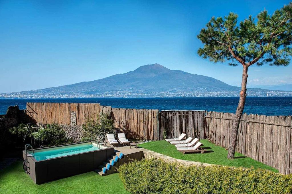 a backyard with a swimming pool and a mountain at GOCCE VILLAS - Villa Degli Dei Scirocco in Vico Equense