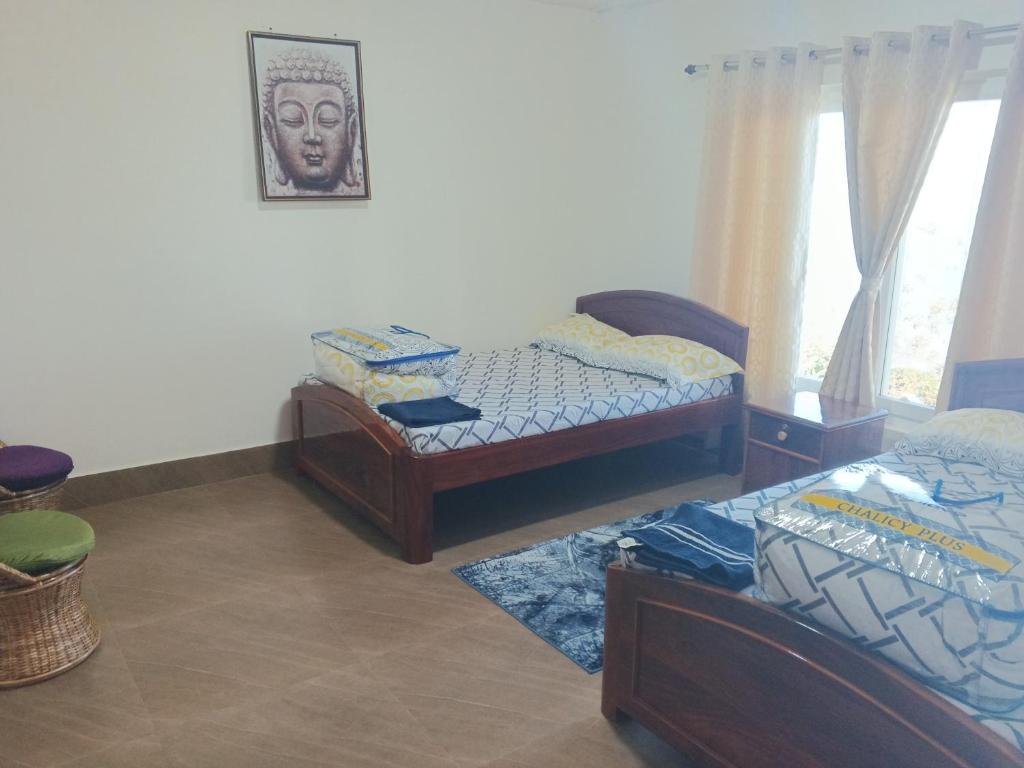 een slaapkamer met 2 bedden en een foto aan de muur bij PEACE HOMESTAY in Takdāh