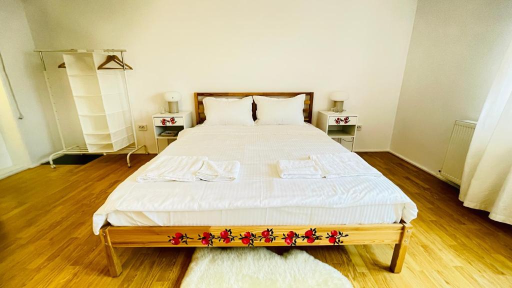ein Schlafzimmer mit einem großen weißen Bett mit Blumen darauf in der Unterkunft BioLocalia House Bucovina in Baloteşti
