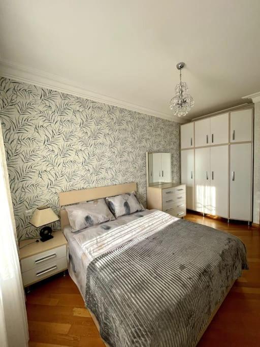 - une chambre avec un grand lit et un mur dans l'établissement Sunny 2-Bedroom Flat in Yerevan., à Erevan