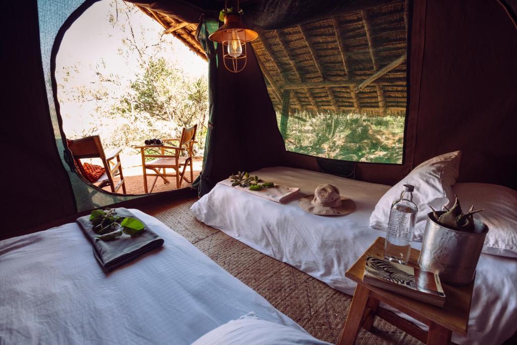 a room with two beds and a table and a mirror at Maji Moto Eco Camp in Maji Moto