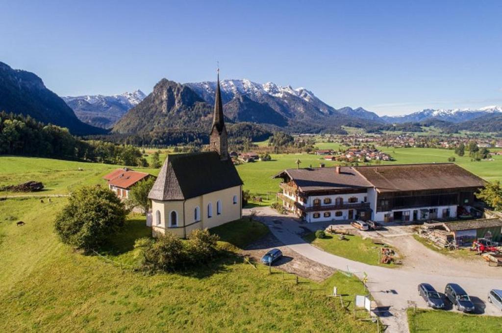 uma vista aérea de uma igreja com montanhas ao fundo em Einsiedlhof em Inzell
