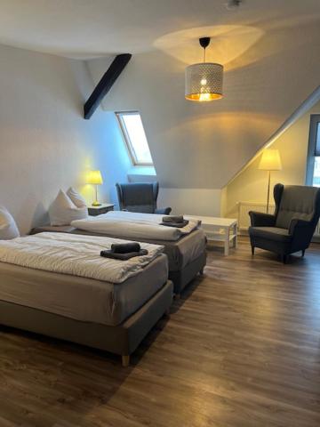 une chambre d'hôtel avec deux lits et une chaise dans l'établissement Gästewohnung Eberswalde, à Eberswalde