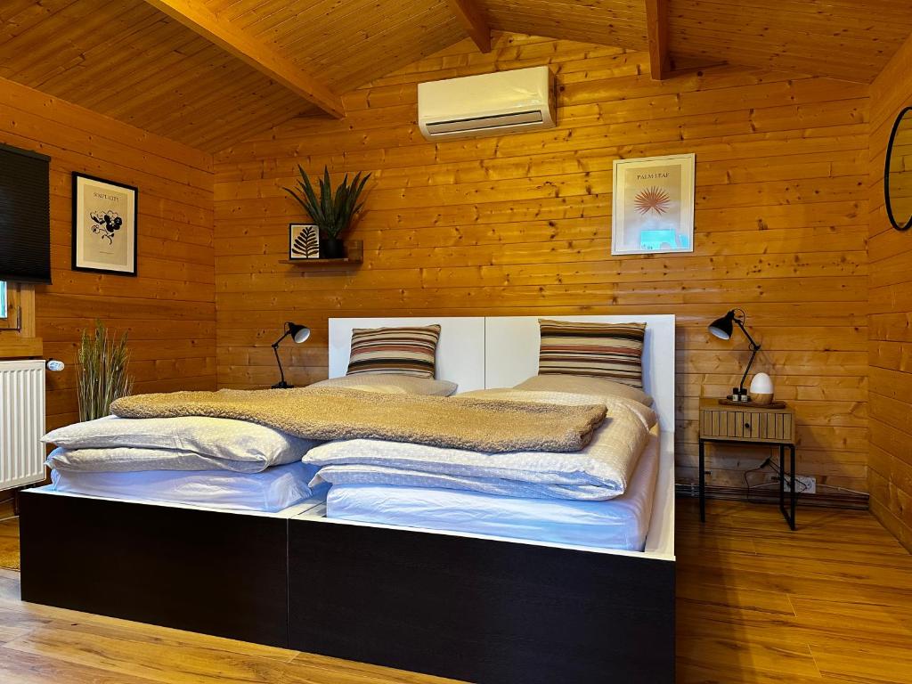 Un dormitorio con una cama grande en una pared de madera. en Glamping Hütte Hygge, en Winterberg