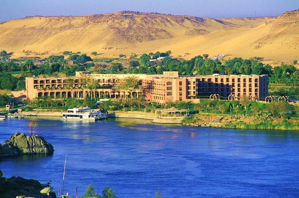 ein Fluss mit einem großen Gebäude auf der Seite in der Unterkunft Pyramisa Island Hotel Aswan in Assuan