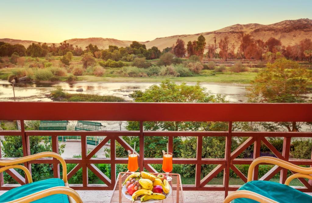 a table with a bowl of fruit and drinks on a balcony at Pyramisa Island Hotel Aswan in Aswan