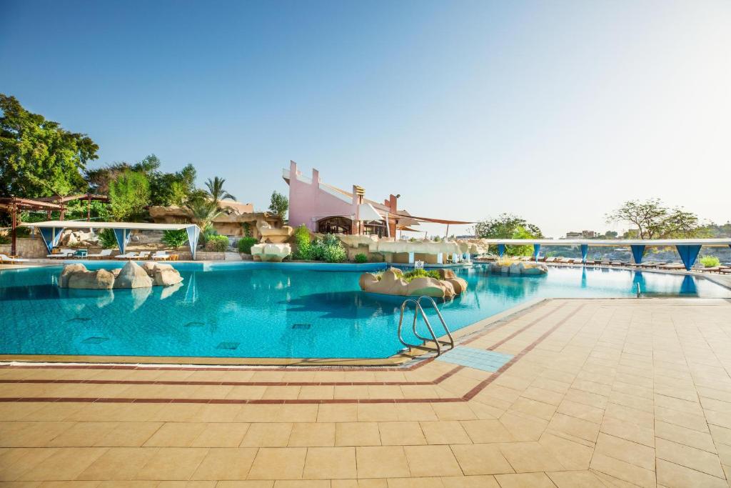 a pool at a resort with blue water at Pyramisa Island Hotel Aswan in Aswan