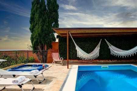una piscina con 2 sillas junto a una casa en Villa de Flores Country Style Villa With Pool, en Massa Lubrense