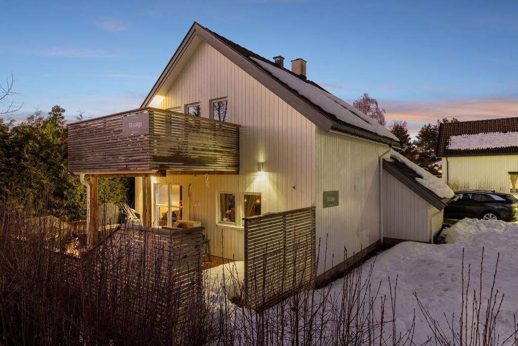 a house with a fence in the snow at Hele Huset - Nært Oslo Lufthavn in Nannestad