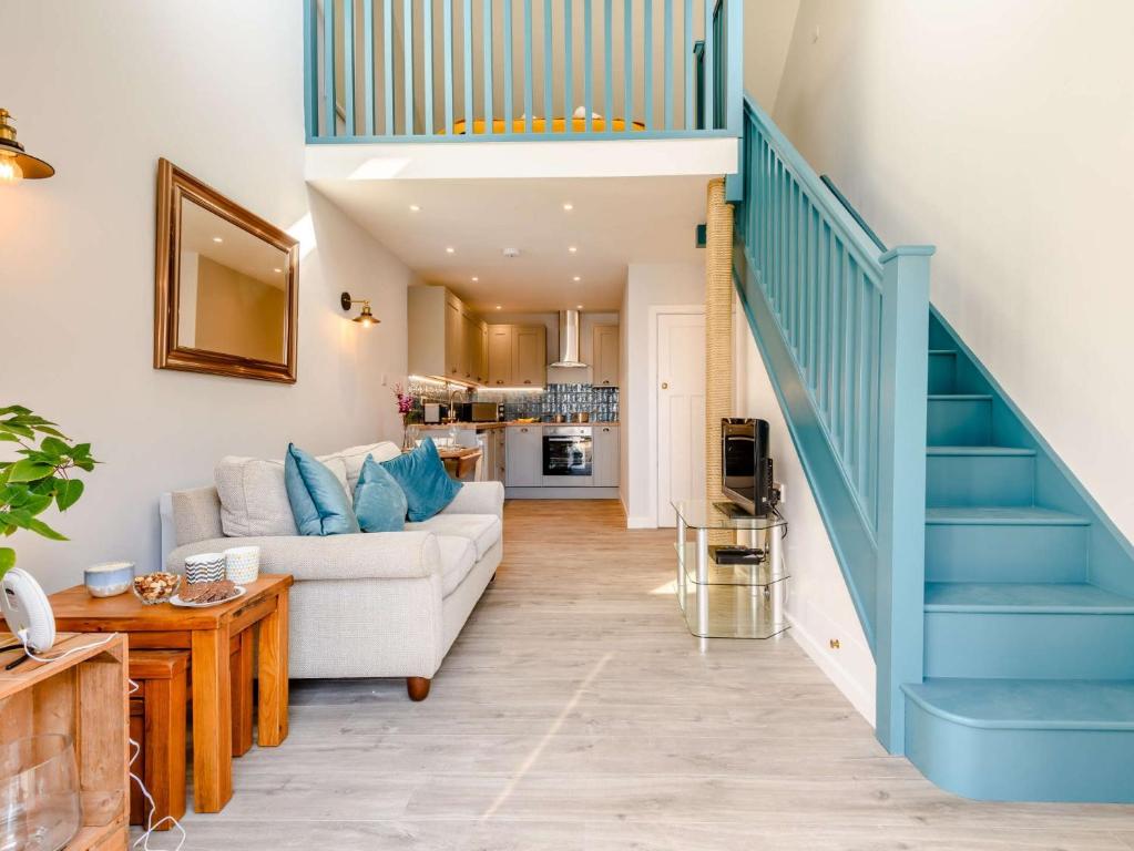 uma sala de estar com um sofá branco e escadas azuis em 1 Bed in Lymington 81429 em Lymington