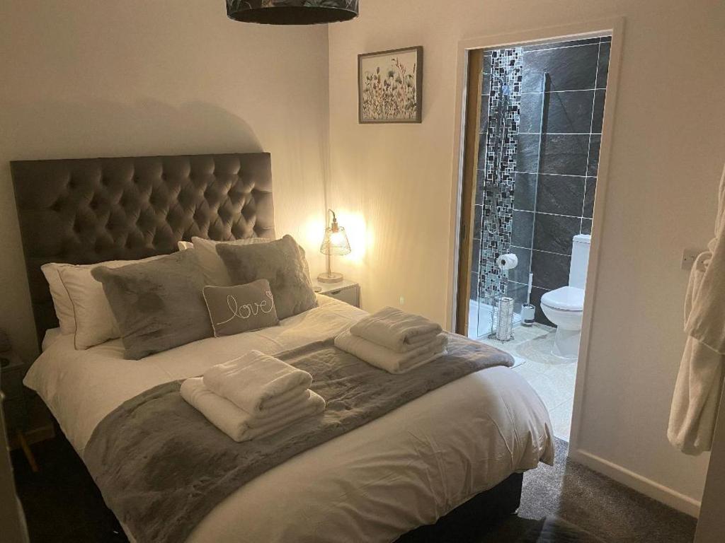 um quarto com uma cama grande e toalhas em Bournemouth Luxury Hot Tub 1 Bed Garden Flat em Bournemouth