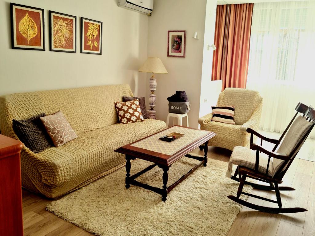 ein Wohnzimmer mit einem Sofa, einem Tisch und einem Stuhl in der Unterkunft CityS in Apatin