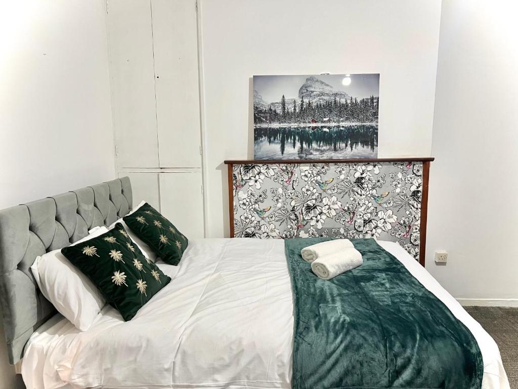 a bedroom with a bed and a picture on the wall at Cosy Home Stay in London