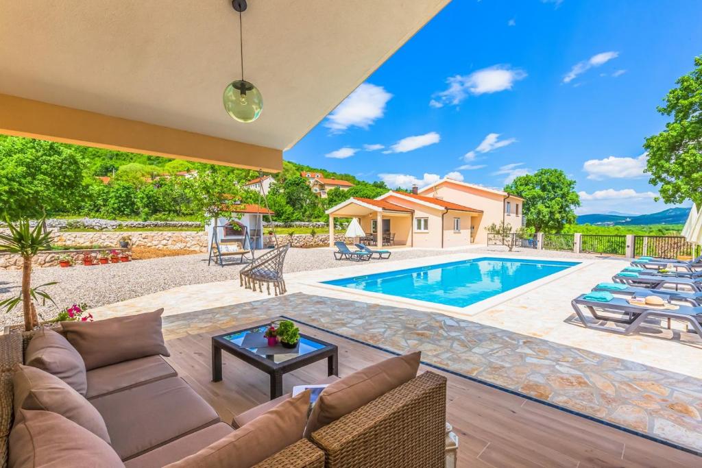 uma villa com uma piscina e um pátio em Villa Patria with Media room, Private pool, Summer kitchen, Gym em Lovreć
