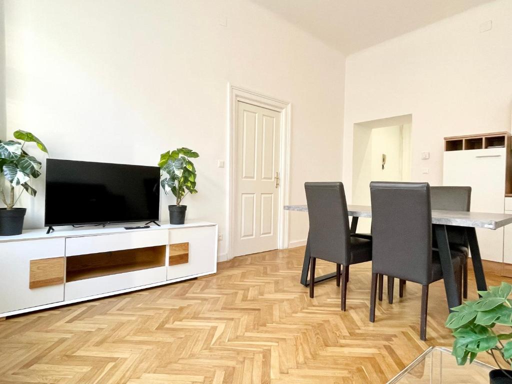a living room with a table and chairs and a television at Premium Residence at famous Vienna Kutschkermarkt in Vienna