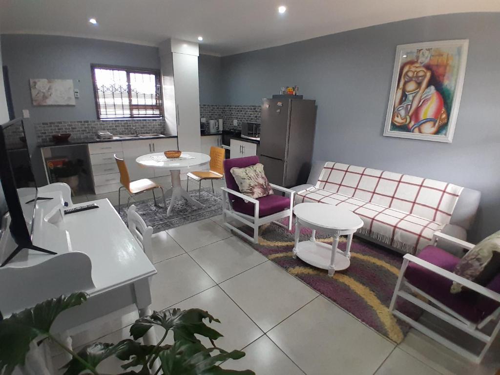 ein Wohnzimmer mit einem Sofa und einem Tisch in der Unterkunft Be-My-Guest Holiday Apartment in Maseru